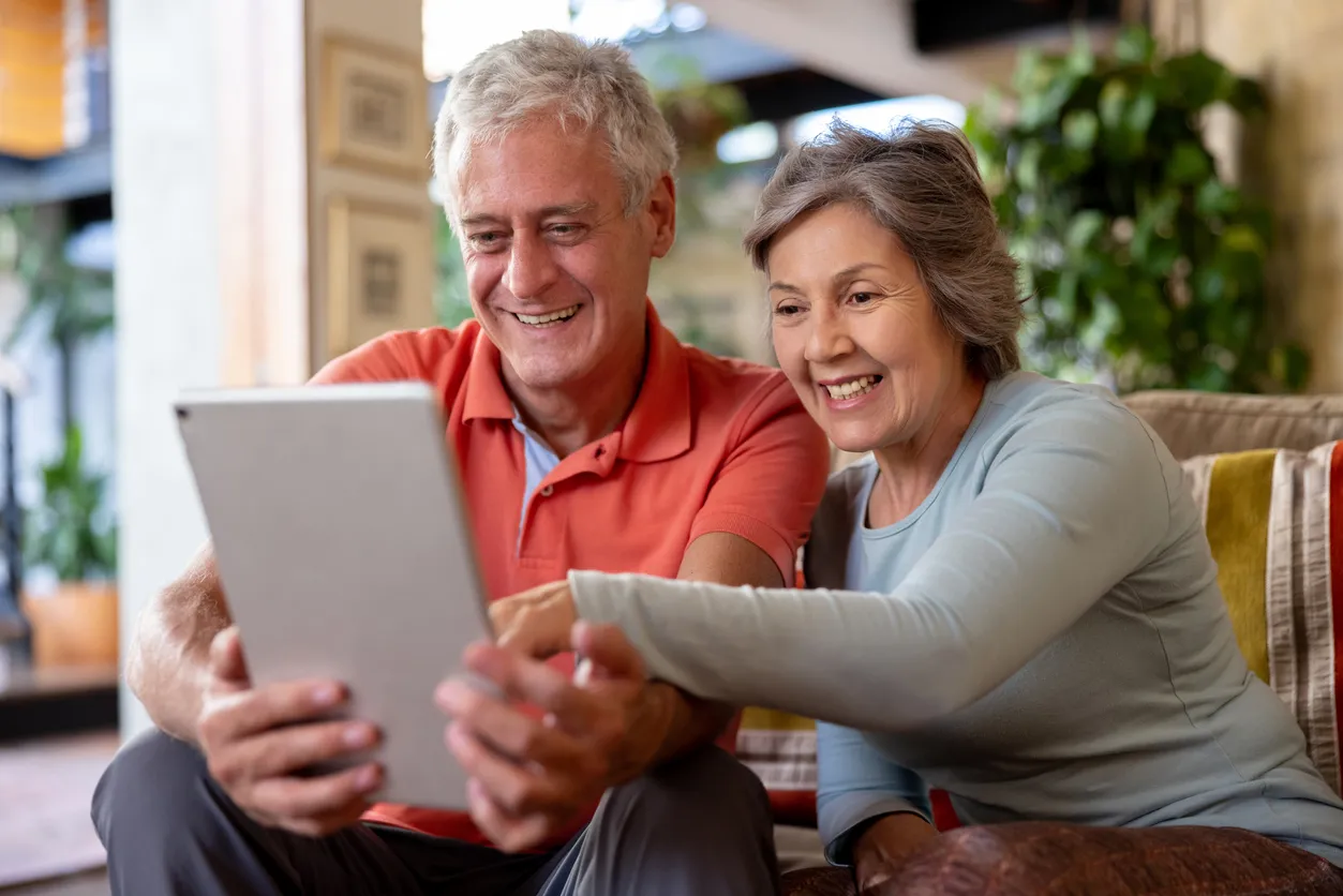 Couple looking at a tablet on a sofa