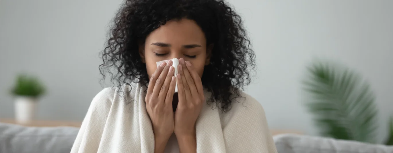 Person holding a tissue to their nose