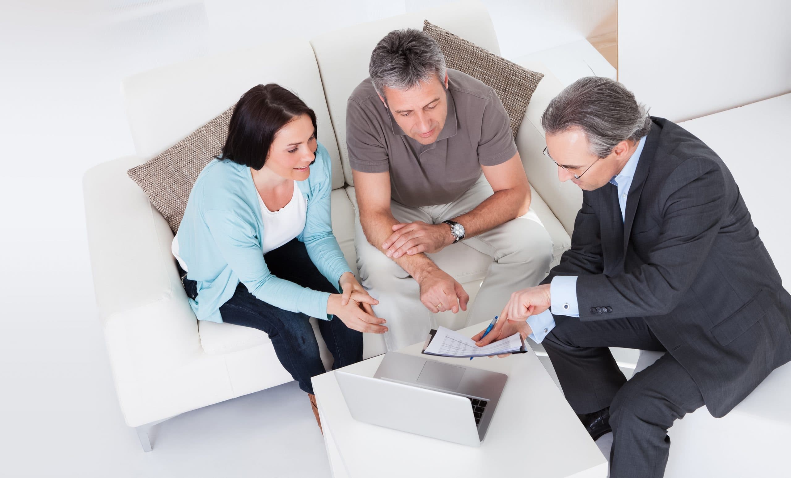 Three people huddled around a laptop