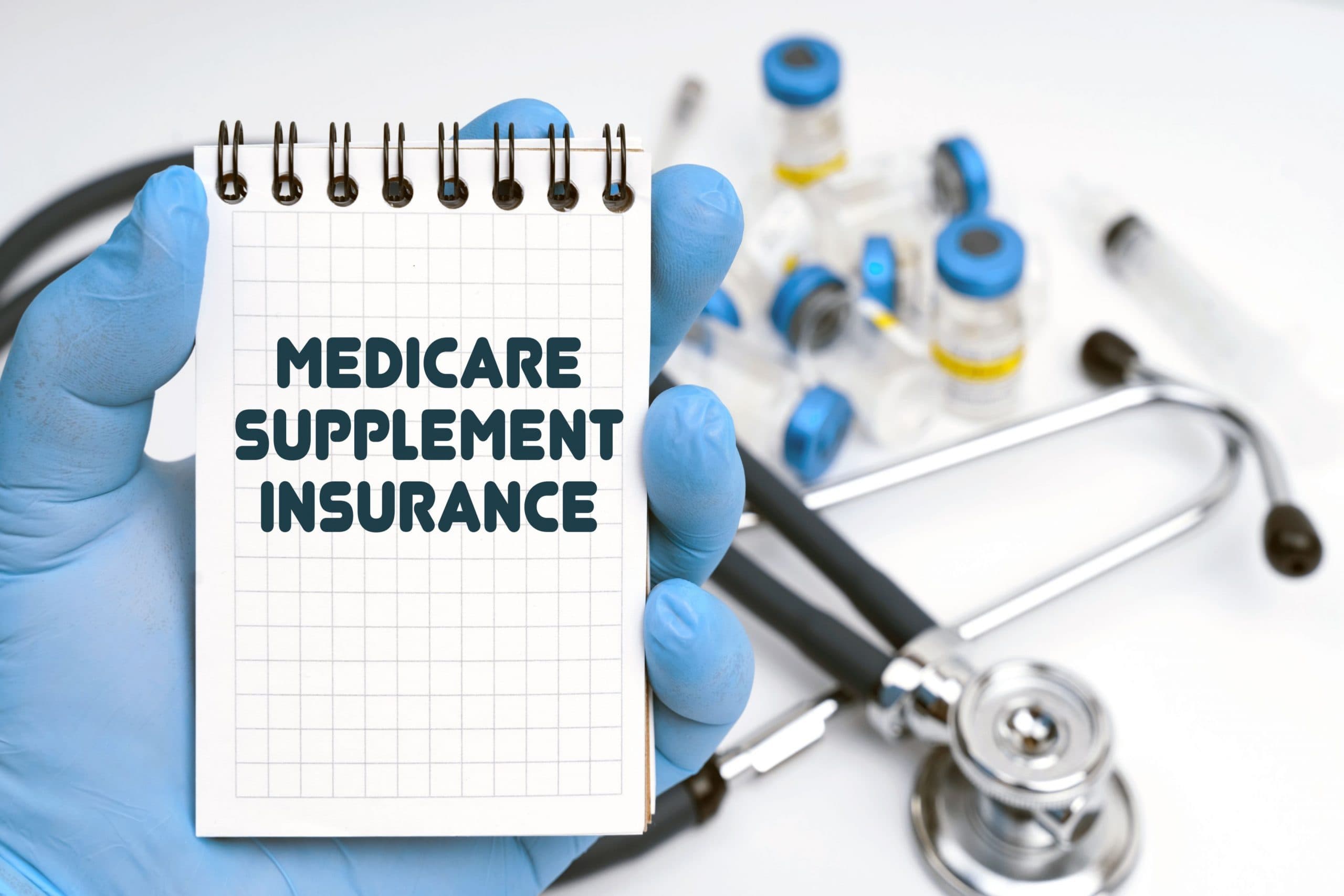 Hand-holding notebook written Medicare Supplement Insurance