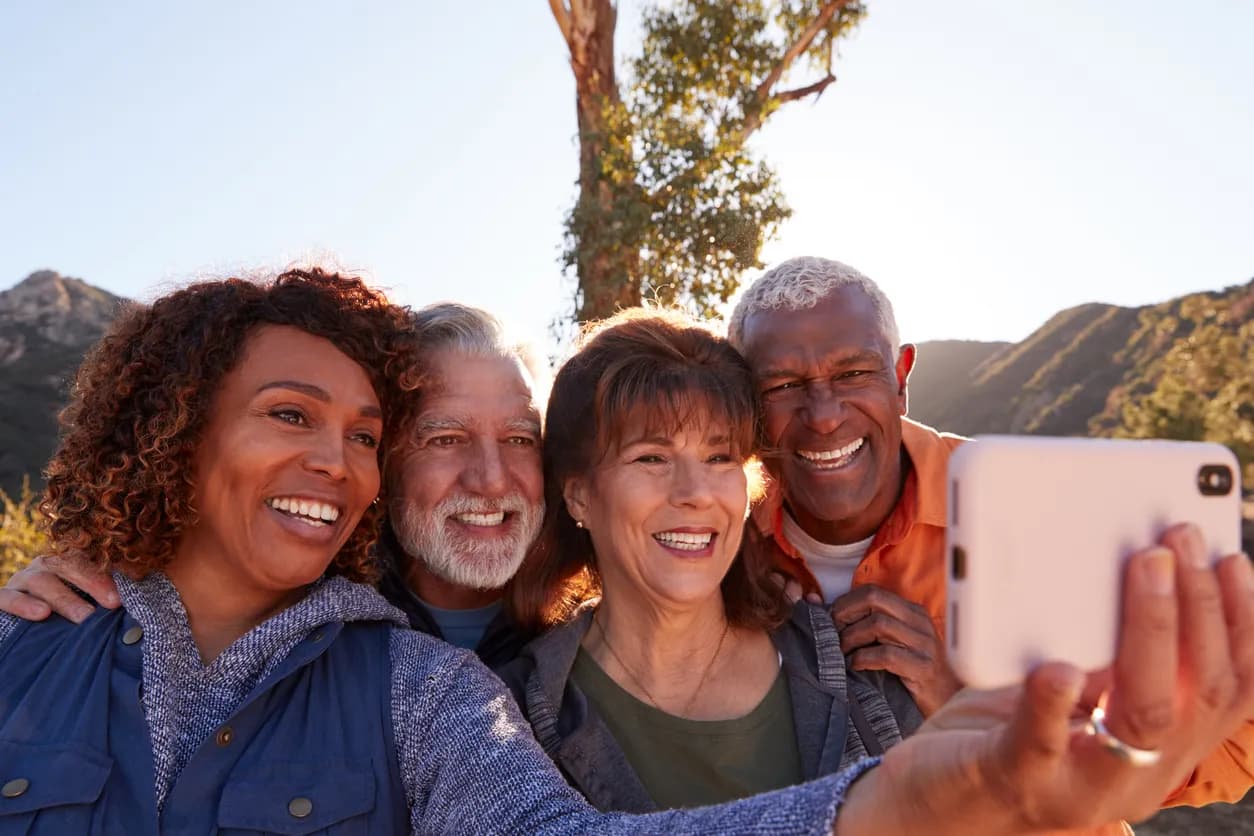 Two couples taking a selfie outdoors