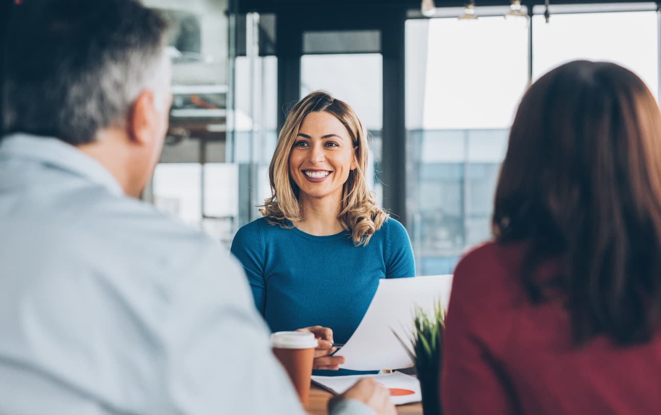 Businesswoman talking to a man and a woman across a table