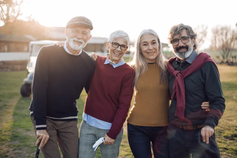Two couples smiling on a golf course