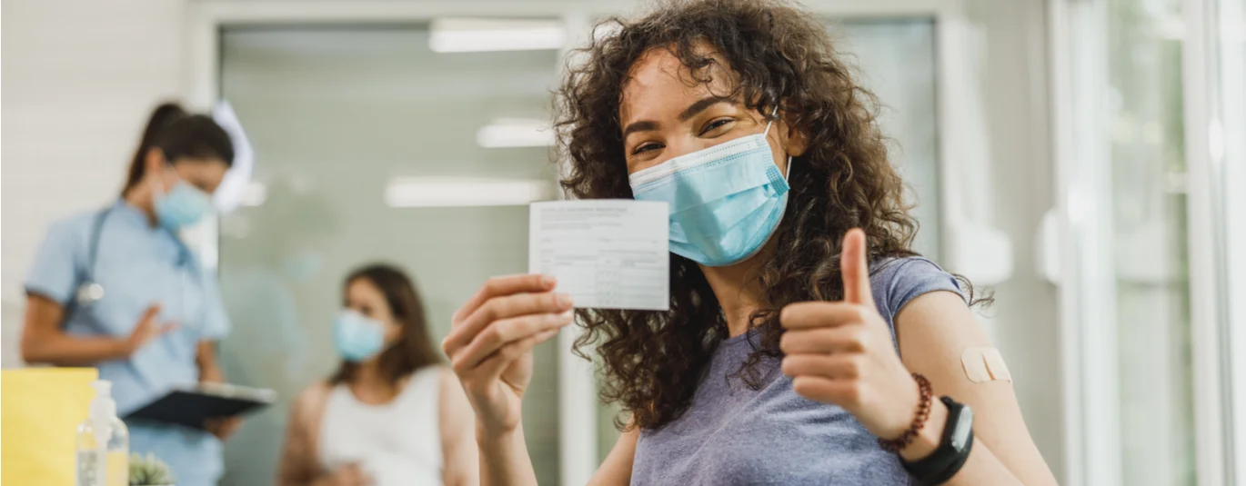 Woman with mask giving a thumbs up