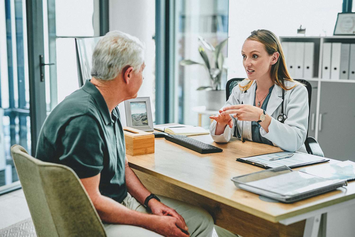 Female doctor talking to older man patient
